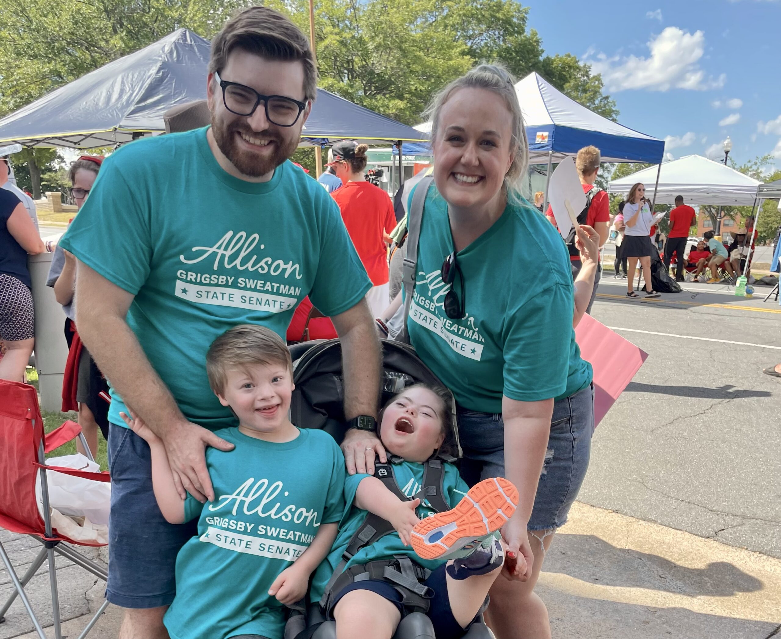 Two adults and two children wearing matching teal Allison for AR shirts